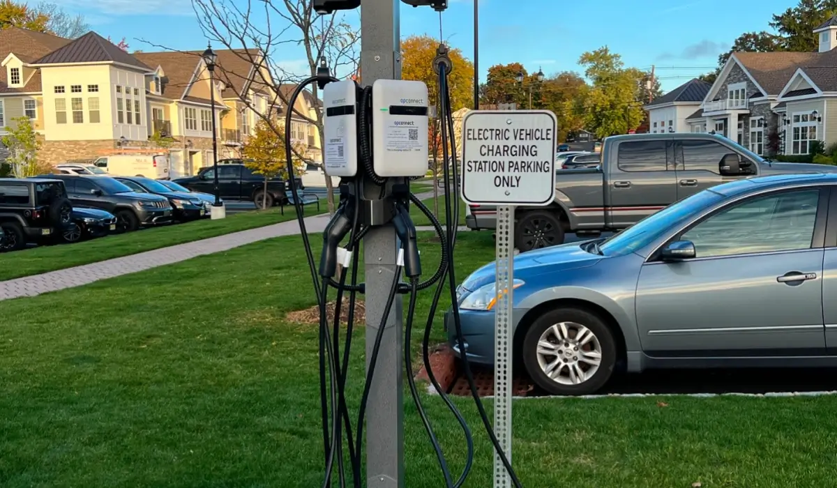 OpConnect dual-port EV charging station in a residential community parking lot with EV-only parking signage