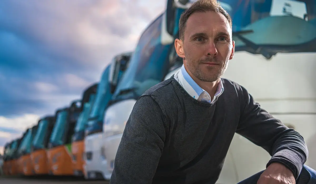 Fleet manager standing in front of a row of commercial vehicles and trucks.