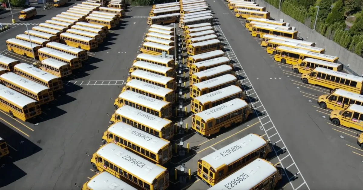 Electric school buses charging at a district bus yard