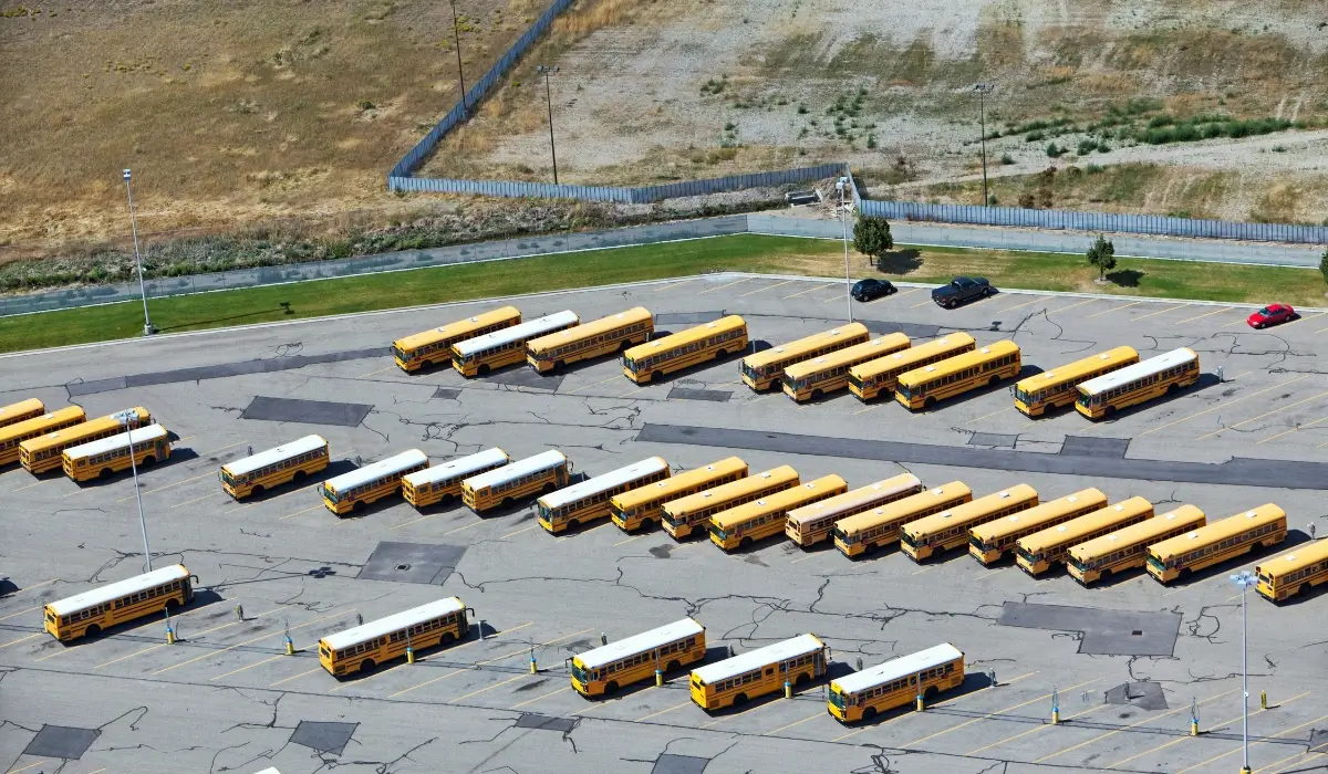 School buses parked in a large depot with space for electric bus charging infrastructure