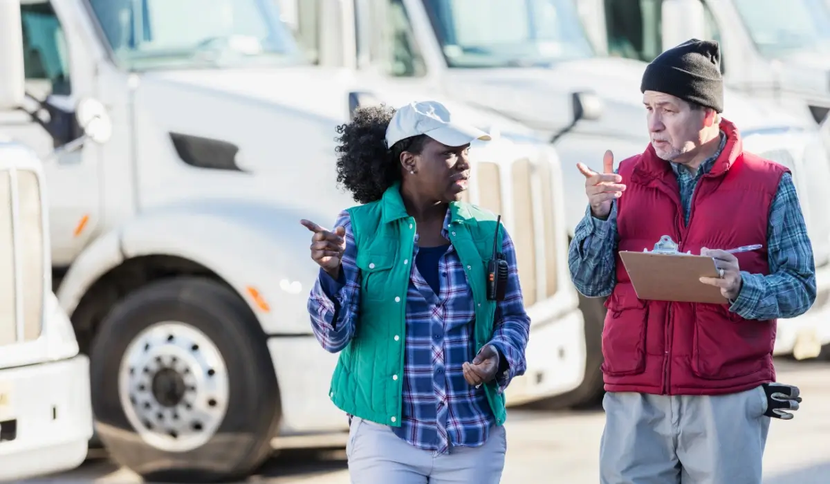 Fleet managers discussing electric truck operations at a commercial fleet facility