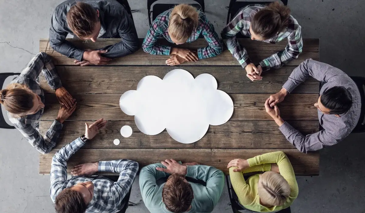 Coworkers gathered around a conference table to discuss workplace electric vehicle charging policies.